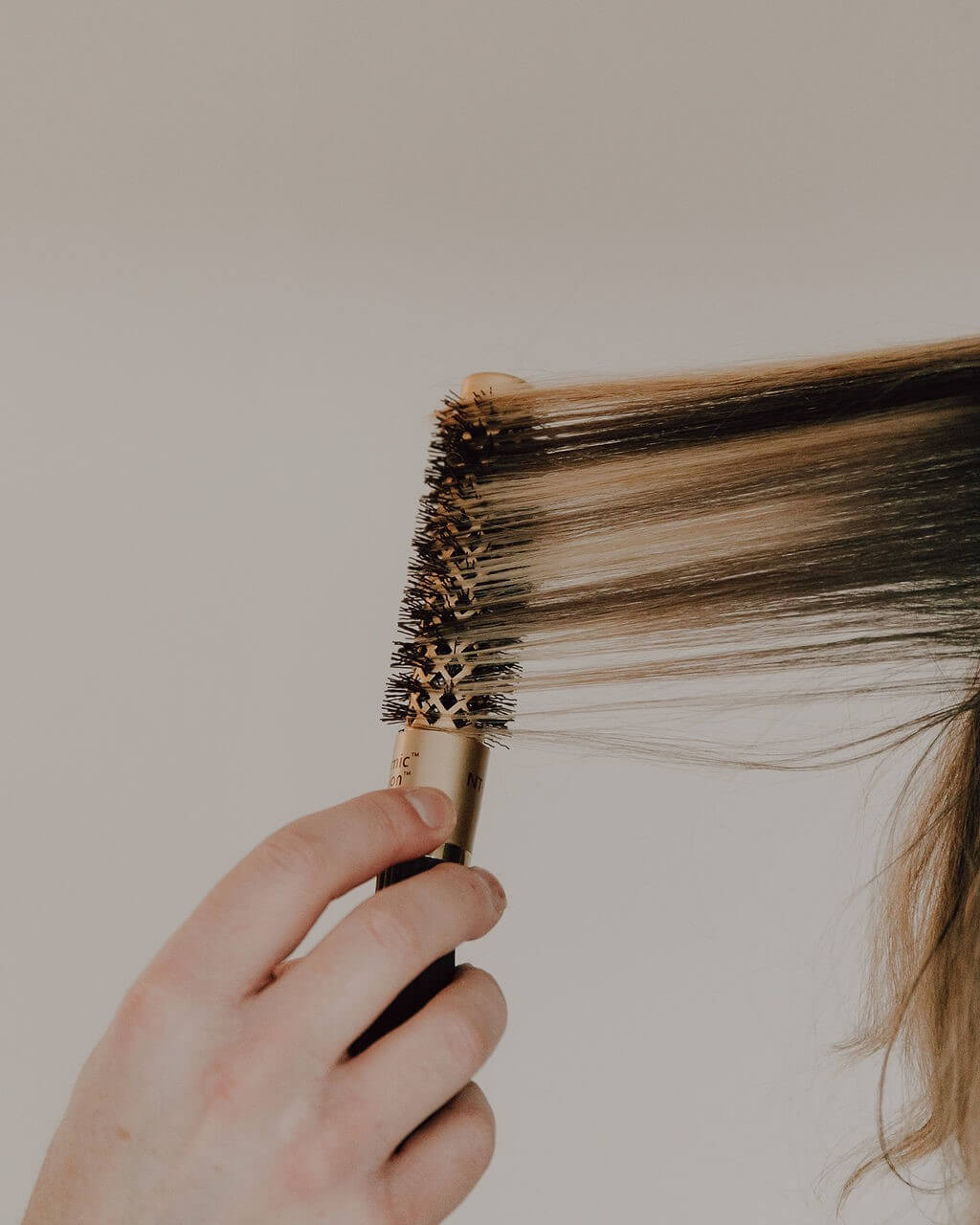 Hairdesign Coiffeur Zürich Bürstet die Haare mit einer Rundbürste